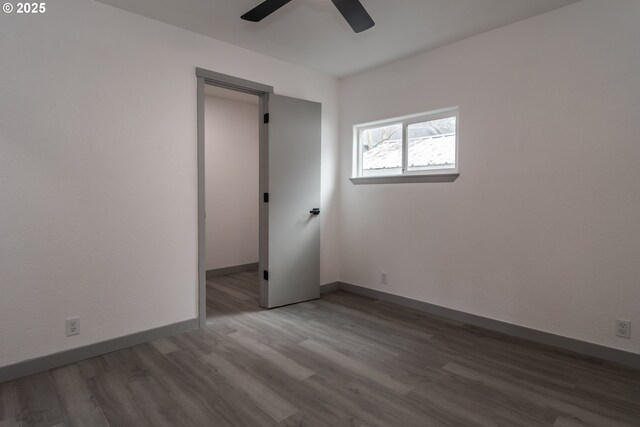 unfurnished room featuring a ceiling fan, baseboards, and wood finished floors