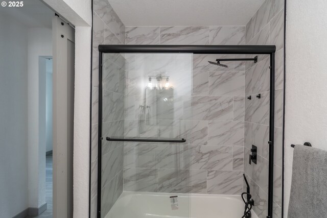bathroom with shower / bath combination with glass door