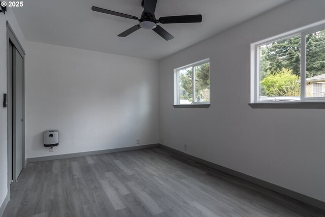 unfurnished room featuring baseboards, ceiling fan, and light wood-style flooring