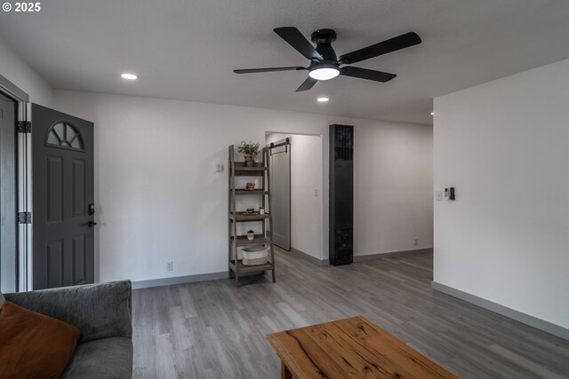 living room with a ceiling fan, baseboards, recessed lighting, and light wood-type flooring