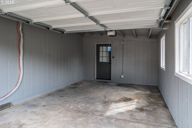garage with wooden walls and a garage door opener