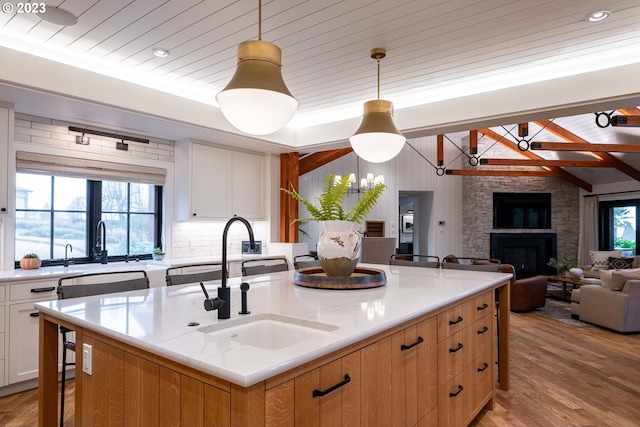 33723 Van Duyn Rd, Eugene, OR 97408 - kitchen featuring a sink, light wood finished floors, an island with sink, open floor plan, and lofted ceiling