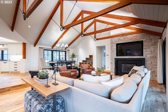 33723 Van Duyn Rd, Eugene, OR 97408 - living area featuring light wood finished floors, a stone fireplace, beam ceiling, a chandelier, and high vaulted ceiling