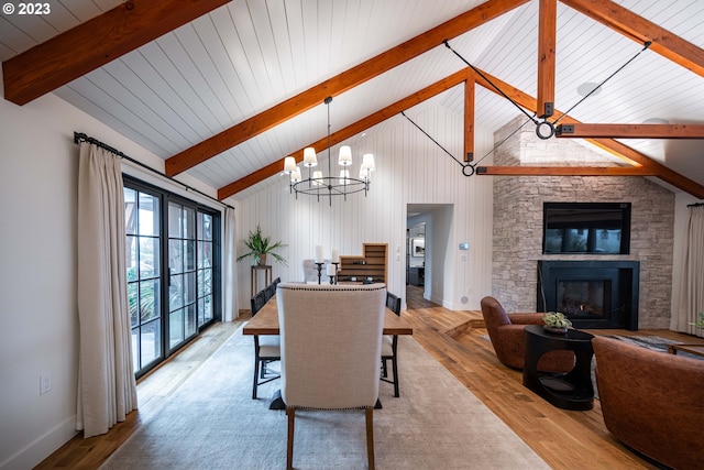 33723 Van Duyn Rd, Eugene, OR 97408 - dining space featuring beamed ceiling, wood finished floors, a stone fireplace, a chandelier, and high vaulted ceiling