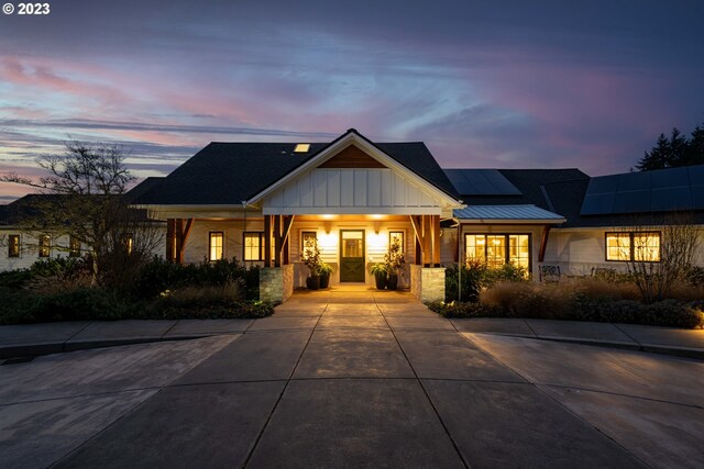 33723 Van Duyn Rd, Eugene, OR 97408 - modern farmhouse style home featuring board and batten siding, roof mounted solar panels, concrete driveway, stone siding, and a porch