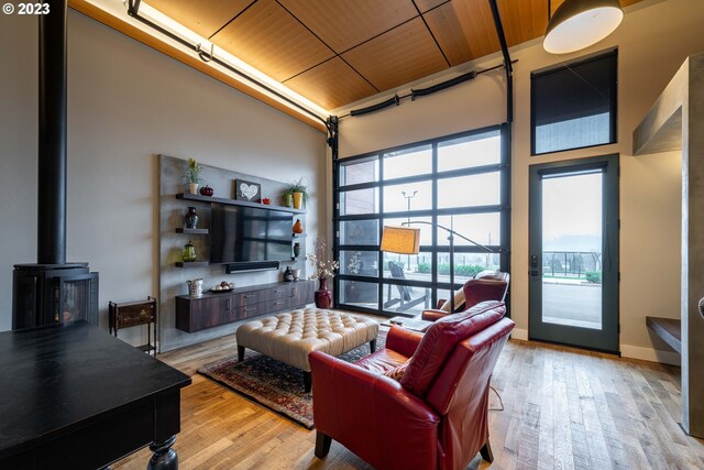 33723 Van Duyn Rd, Eugene, OR 97408 - living area featuring wooden ceiling, a high ceiling, light wood-style flooring, and a wood stove