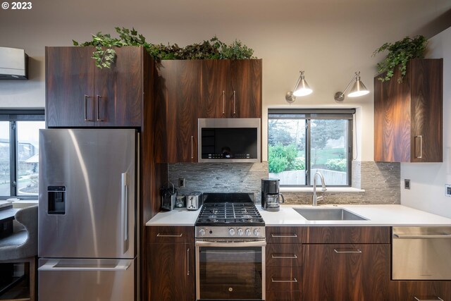 33723 Van Duyn Rd, Eugene, OR 97408 - kitchen featuring appliances with stainless steel finishes, a sink, modern cabinets, light countertops, and backsplash