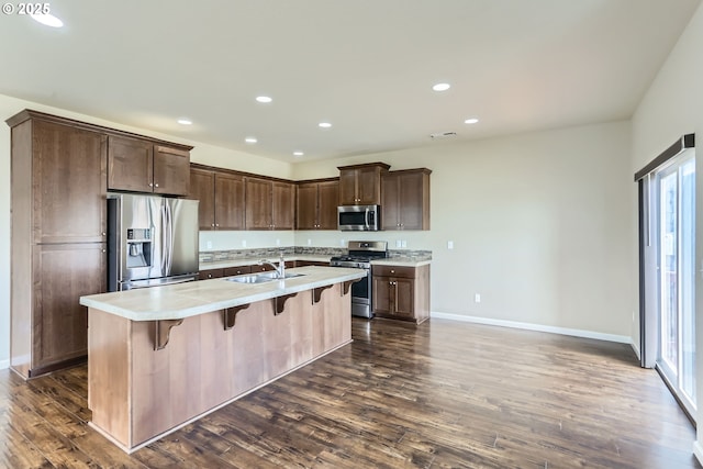 7359 NW 168th Ave, Portland, OR 97229 - kitchen featuring appliances with stainless steel finishes, light countertops, dark wood-style floors, recessed lighting, and a breakfast bar area