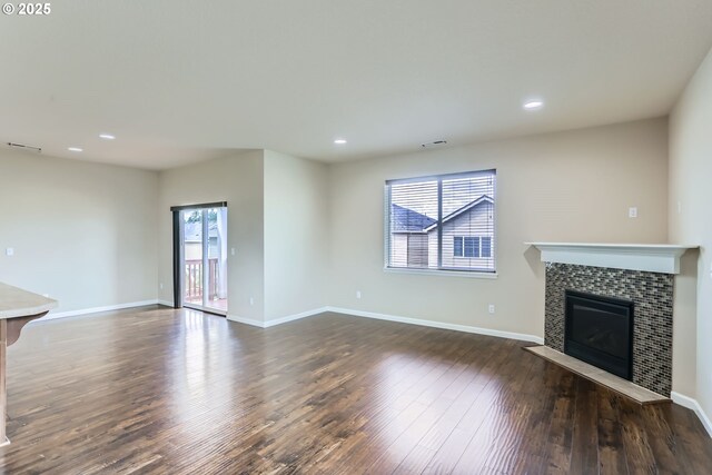 7359 NW 168th Ave, Portland, OR 97229 - unfurnished living room featuring healthy amount of natural light, a tiled fireplace, dark wood-style floors, and recessed lighting