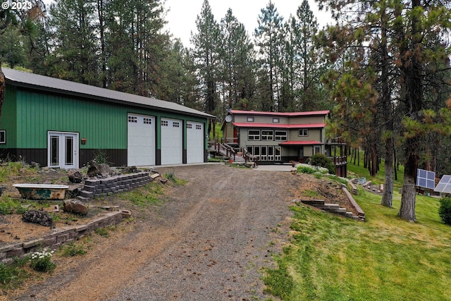 view of front of property with an outdoor structure, french doors, a front lawn, and a garage