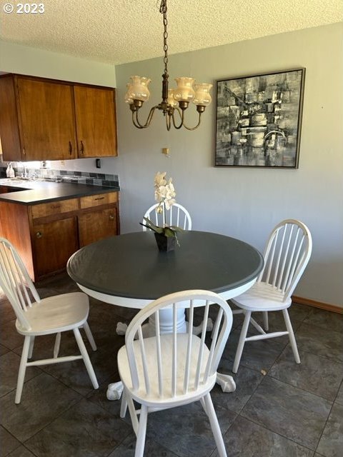 dining space with a notable chandelier and a textured ceiling