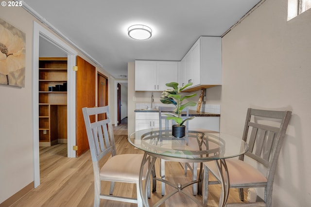 dining area with light hardwood / wood-style floors and sink