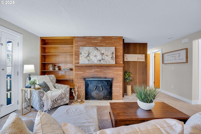 living room with a textured ceiling, built in features, and a healthy amount of sunlight