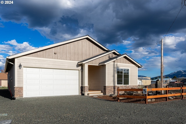 223 N Johnson St, Prairie City, OR 97869 - view of front of home with stone siding, asphalt driveway, a garage, and a mountain view
