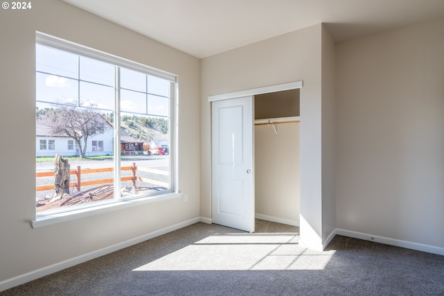 223 N Johnson St, Prairie City, OR 97869 - unfurnished bedroom with multiple windows, carpet flooring, and a closet