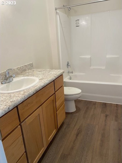 223 N Johnson St, Prairie City, OR 97869 - full bath featuring wood finished floors, vanity, and shower / tub combination