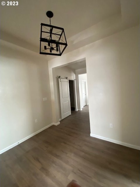 223 N Johnson St, Prairie City, OR 97869 - unfurnished dining area with dark wood-type flooring and a chandelier