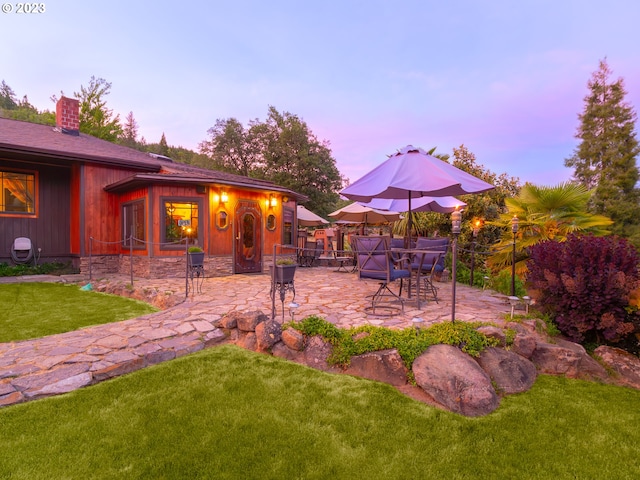 yard at dusk featuring a patio area