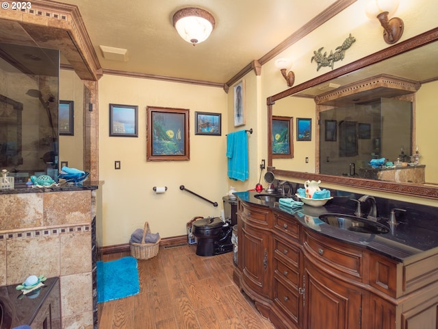 interior space with double sink, hardwood / wood-style floors, walk in shower, oversized vanity, and ornamental molding