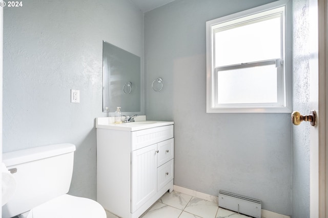 bathroom with toilet, vanity, and a baseboard radiator