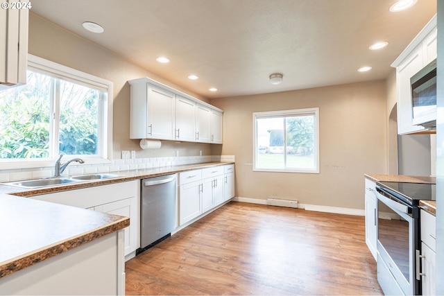 kitchen featuring sink, white cabinets, stainless steel appliances, and light wood-type flooring