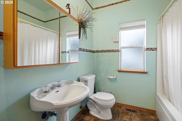 full bathroom featuring toilet, shower / bath combination with curtain, and sink