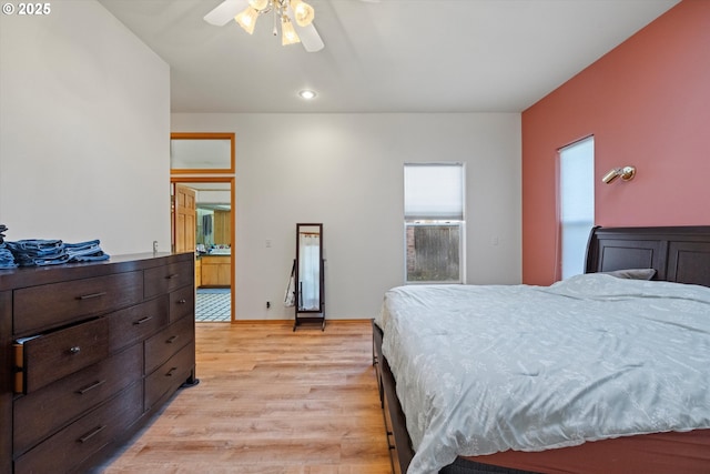 bedroom with light wood-type flooring, ceiling fan, and ensuite bathroom