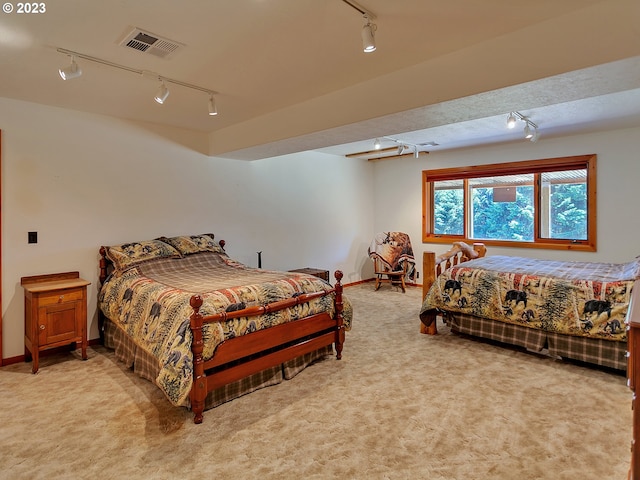 carpeted bedroom featuring track lighting