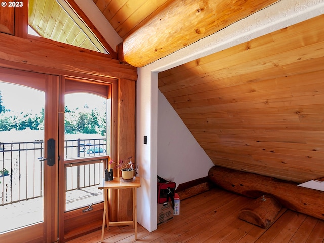 interior space with wooden ceiling, vaulted ceiling, and light hardwood / wood-style flooring