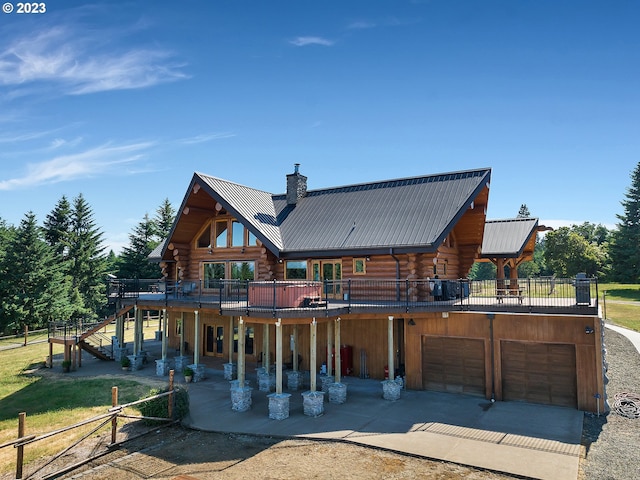 back of property with a deck, a balcony, and a garage