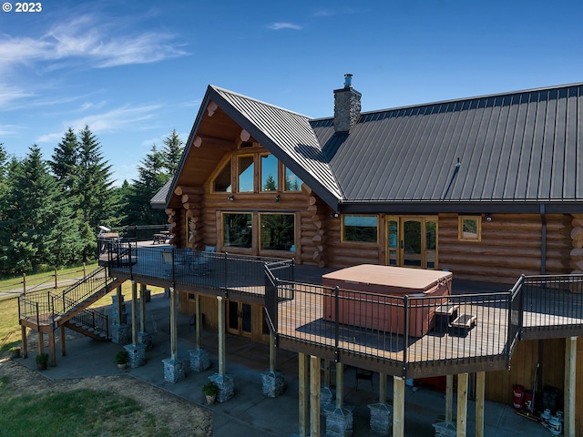 back of property with a deck and a patio area