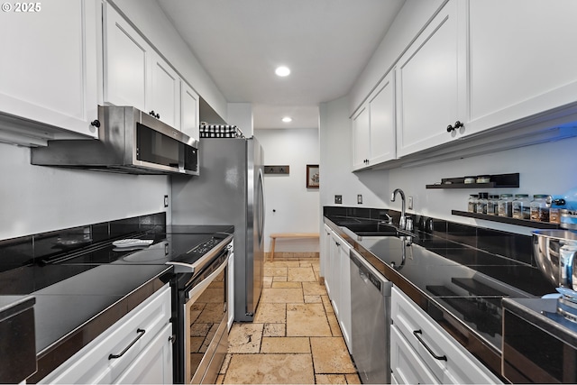 5250 S Landing Dr Unit 111B1, Portland, OR 97239 - kitchen with stainless steel appliances, stone tile flooring, white cabinetry, recessed lighting, and tile counters