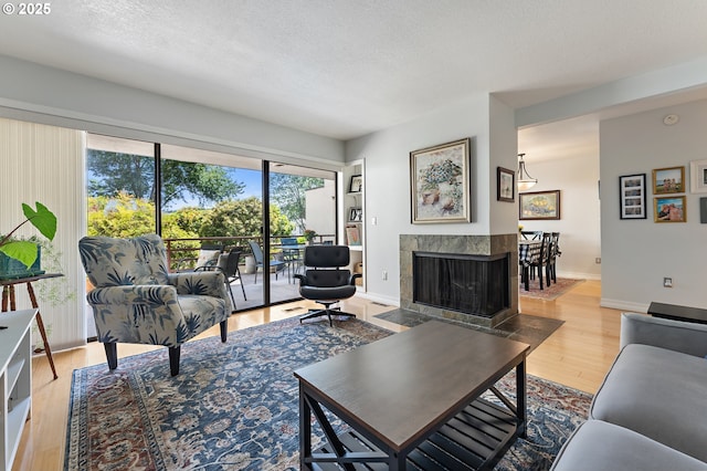 5250 S Landing Dr Unit 111B1, Portland, OR 97239 - living area with wood finished floors, a textured ceiling, and a fireplace