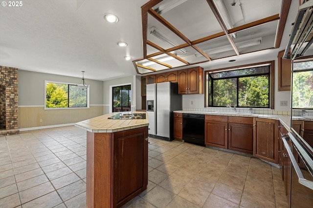 11185 SE Saint Lucy Ln, Happy Valley, OR 97086 - kitchen with black appliances, tile countertops, a center island, a wainscoted wall, and recessed lighting