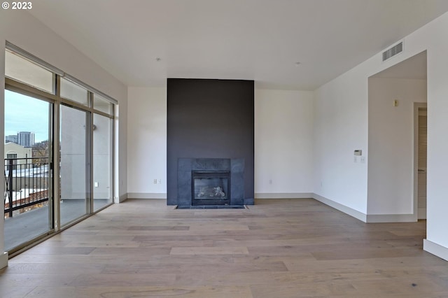 unfurnished living room with a fireplace and light wood-type flooring