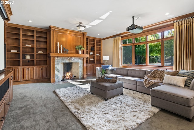 living room with crown molding, light colored carpet, a high end fireplace, and a skylight