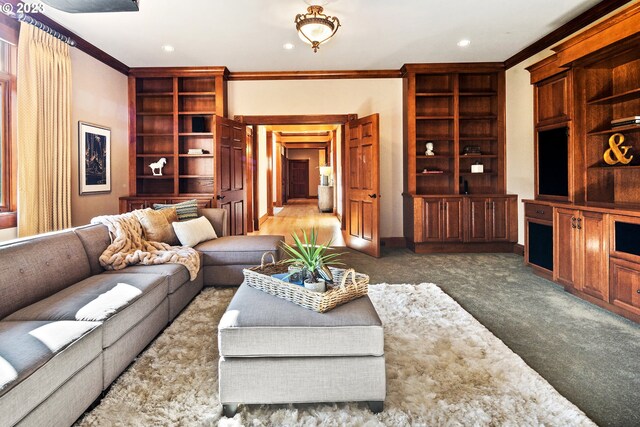 living room featuring crown molding, built in shelves, and dark colored carpet