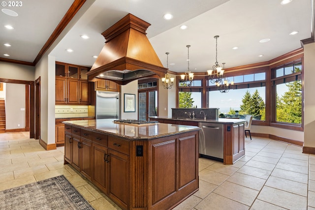 kitchen with backsplash, custom exhaust hood, stainless steel appliances, a center island, and a chandelier