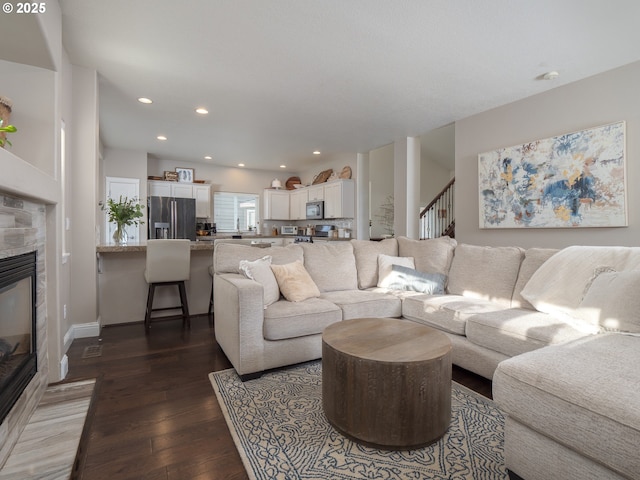 living room with dark wood-type flooring and a fireplace