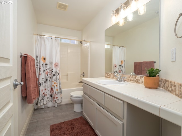 full bathroom featuring tasteful backsplash, shower / tub combo with curtain, vanity, and toilet