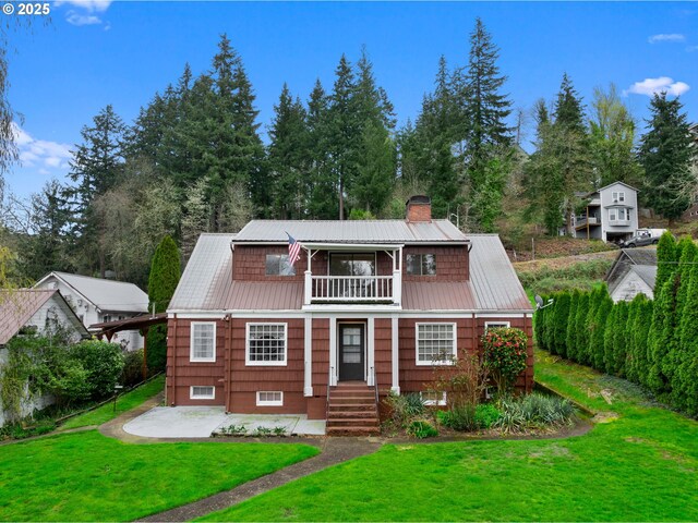 510 SE Shafford St, Estacada, OR 97023 - view of front of property featuring a chimney, a front lawn, metal roof, and a balcony
