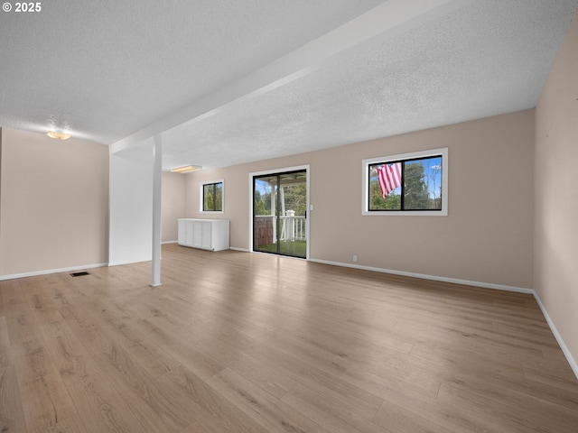 510 SE Shafford St, Estacada, OR 97023 - unfurnished living room featuring light wood-type flooring, baseboards, visible vents, and a textured ceiling