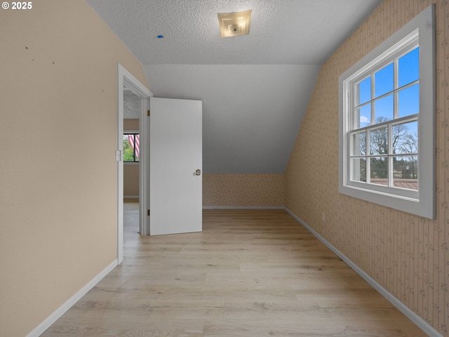 510 SE Shafford St, Estacada, OR 97023 - additional living space with baseboards, wallpapered walls, a textured ceiling, lofted ceiling, and wood finished floors
