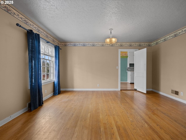 510 SE Shafford St, Estacada, OR 97023 - spare room with visible vents, baseboards, light wood-type flooring, and a textured ceiling