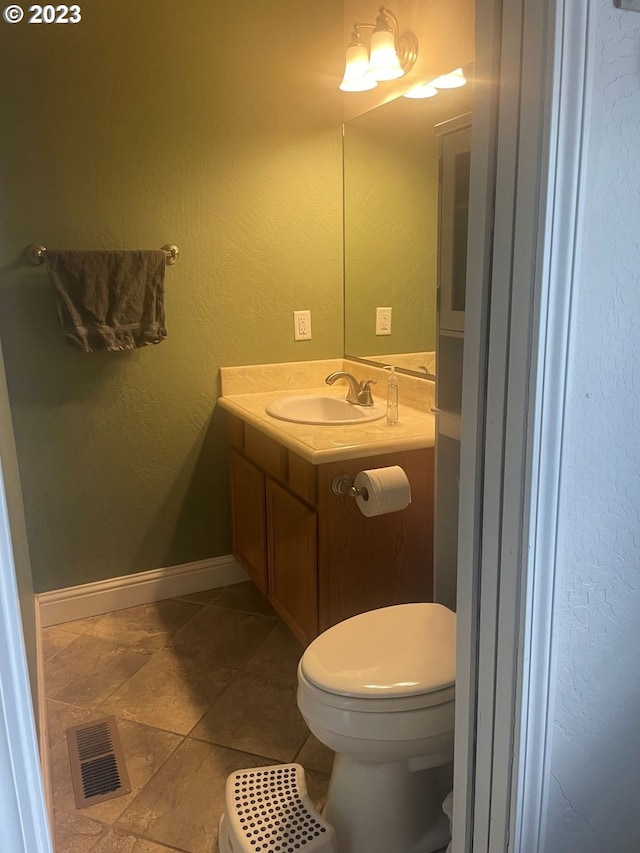 bathroom featuring toilet, tile floors, and oversized vanity