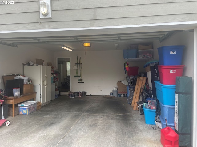 garage featuring a garage door opener and white refrigerator