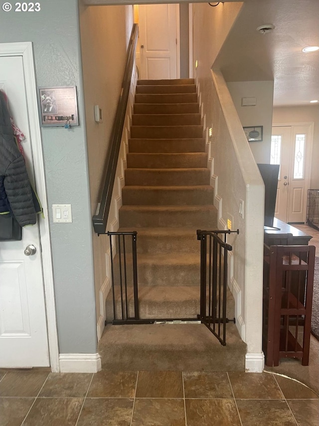 stairs featuring dark tile floors