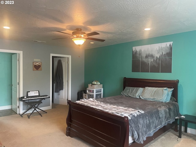 carpeted bedroom with ceiling fan, a closet, and a textured ceiling