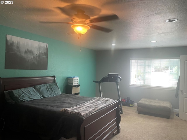 carpeted bedroom featuring a textured ceiling and ceiling fan