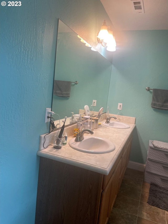 bathroom with dual vanity and tile flooring